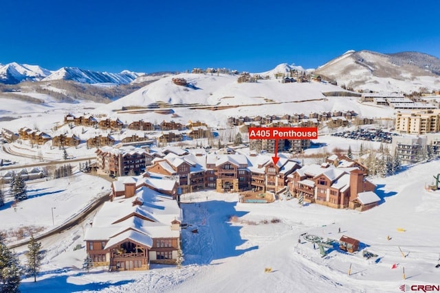 snowy aerial view with a mountain view