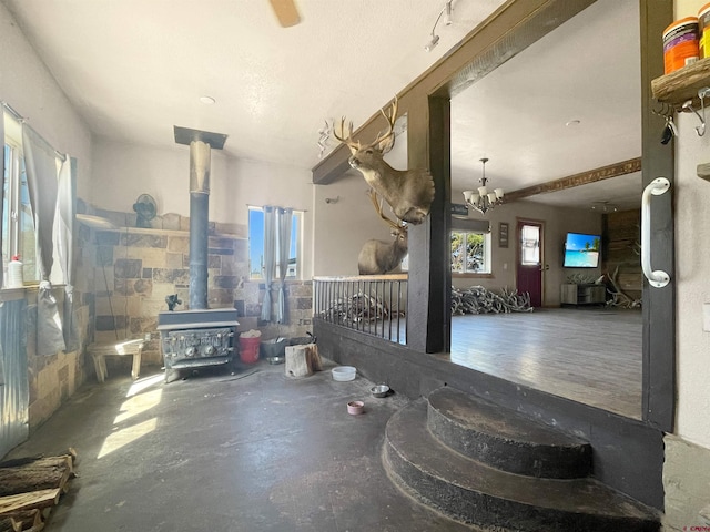 175 County Road J6, Egnar, CO 81325 - living area with a wood stove, unfinished concrete floors, plenty of natural light, and a chandelier
