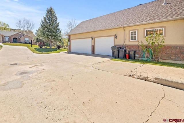 1060 Alta Vista Dr, Craig, CO 81625 - view of property exterior featuring concrete driveway, brick siding, a garage, stucco siding, and a shingled roof