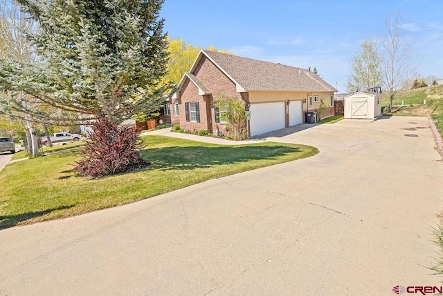 1060 Alta Vista Dr, Craig, CO 81625 - view of home's exterior featuring a storage unit, concrete driveway, brick siding, a yard, and an outdoor structure