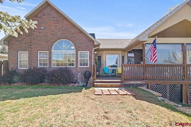 1060 Alta Vista Dr, Craig, CO 81625 - view of front facade with brick siding, a wooden deck, and a front lawn