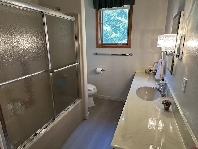 20 Meadow Ln, Monte Vista, CO 81144 - bathroom featuring wood finished floors, toilet, baseboards, vanity, and bath / shower combo with glass door