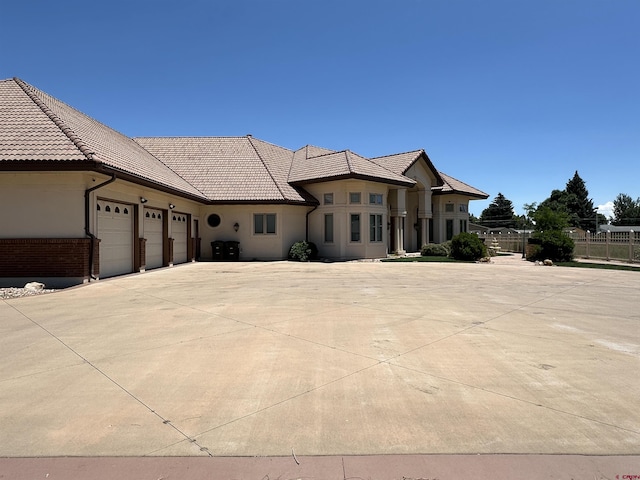 20 Meadow Ln, Monte Vista, CO 81144 - view of front of property featuring fence, an attached garage, stucco siding, and a tiled roof