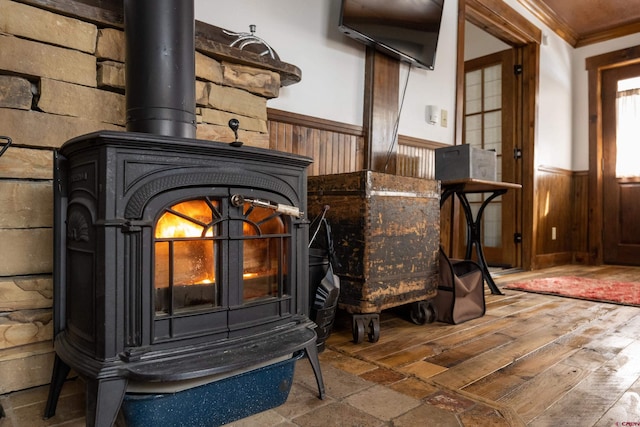 209 Whiterock Ave, Crested Butte, CO 81224 - detailed view of a wood stove, wainscoting, crown molding, wooden walls, and wood finished floors