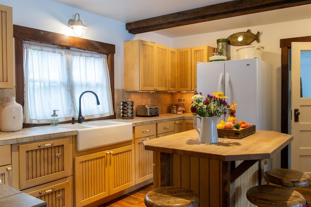 209 Whiterock Ave, Crested Butte, CO 81224 - kitchen featuring butcher block countertops, freestanding refrigerator, a sink, decorative backsplash, and beam ceiling