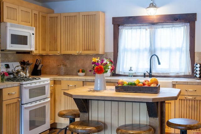 209 Whiterock Ave, Crested Butte, CO 81224 - kitchen featuring white appliances, a breakfast bar, wooden counters, backsplash, and a sink