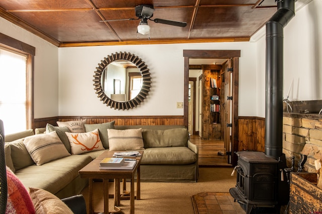 209 Whiterock Ave, Crested Butte, CO 81224 - carpeted living area featuring a wood stove, a wainscoted wall, and wood walls
