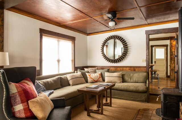 209 Whiterock Ave, Crested Butte, CO 81224 - living room with a wood stove, crown molding, a ceiling fan, wainscoting, and carpet flooring