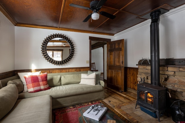 209 Whiterock Ave, Crested Butte, CO 81224 - living area with hardwood / wood-style floors, a wainscoted wall, a wood stove, ceiling fan, and ornamental molding