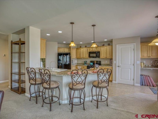 338 Escobar Ave, Pagosa Springs, CO 81147 - kitchen featuring black appliances, a sink, baseboards, a peninsula, and a kitchen bar
