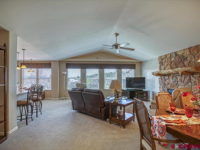 338 Escobar Ave, Pagosa Springs, CO 81147 - living room featuring a ceiling fan, light colored carpet, lofted ceiling, and a stone fireplace