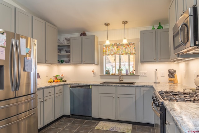kitchen featuring appliances with stainless steel finishes, dark tile patterned flooring, a sink, gray cabinetry, and open shelves