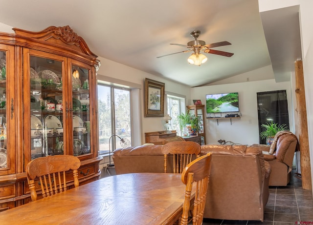 dining room featuring lofted ceiling, ceiling fan, and dark tile patterned flooring