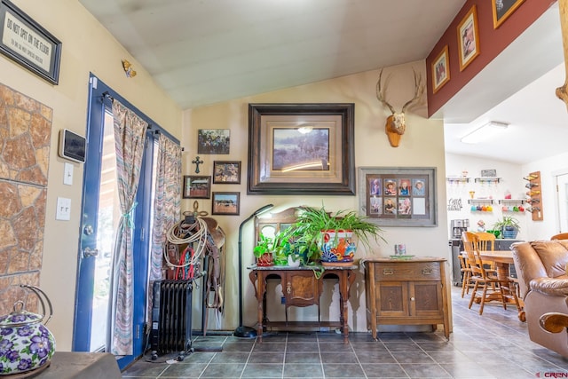 interior space with vaulted ceiling, tile patterned flooring, and radiator