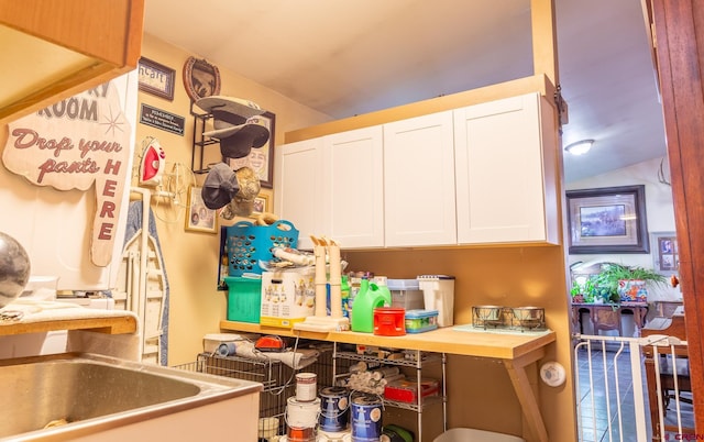 kitchen featuring lofted ceiling and white cabinetry
