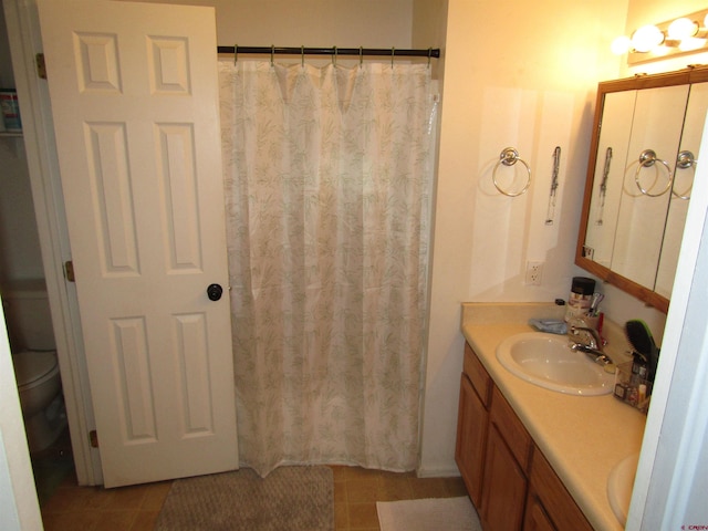 bathroom featuring double vanity, toilet, and a shower with curtain