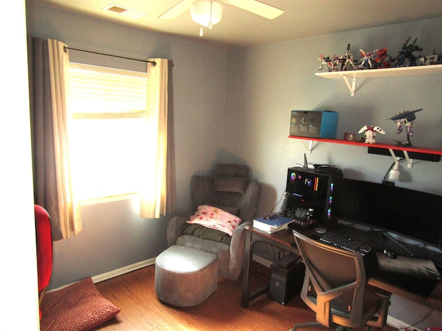 office featuring healthy amount of natural light, ceiling fan, and wood finished floors