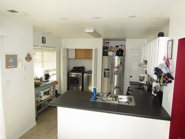 kitchen featuring stainless steel fridge, exhaust hood, a peninsula, separate washer and dryer, and a sink