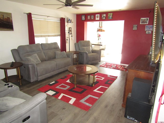 living area with a ceiling fan and wood finished floors