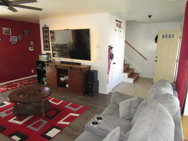living area featuring stairway, wood finished floors, and ceiling fan