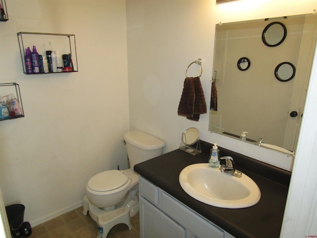 bathroom featuring vanity, toilet, and baseboards