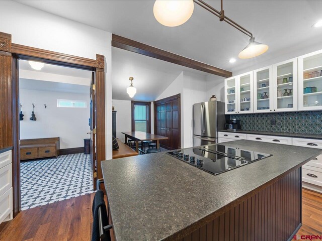 645 2nd St, Ouray, CO 81427 - kitchen featuring freestanding refrigerator, black electric cooktop, dark countertops, dark wood-style floors, and white cabinetry