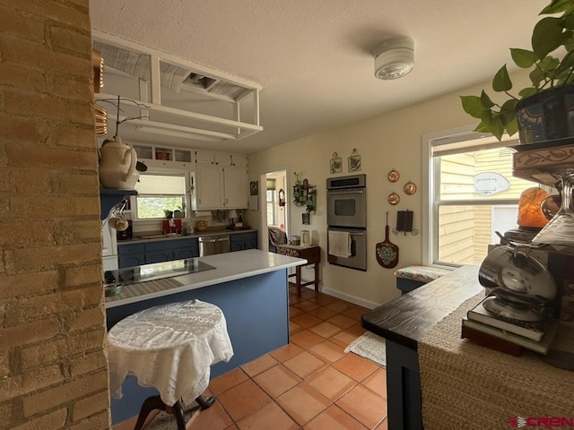 15556 D Rd, Delta, CO 81416 - kitchen with appliances with stainless steel finishes, light tile patterned flooring, white cabinets, and baseboards