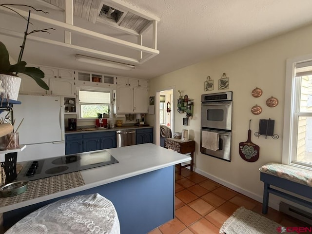 15556 D Rd, Delta, CO 81416 - kitchen featuring stainless steel appliances, plenty of natural light, light tile patterned floors, and baseboard heating