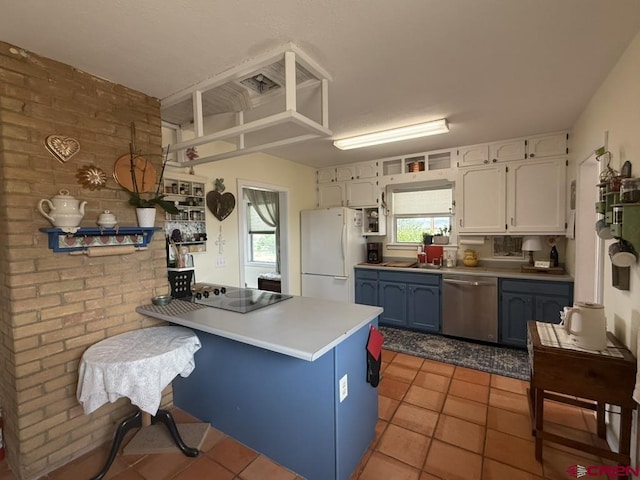 15556 D Rd, Delta, CO 81416 - kitchen featuring dishwasher, freestanding refrigerator, a peninsula, white cabinetry, and light tile patterned floors