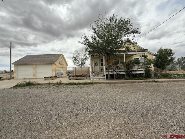 15556 D Rd, Delta, CO 81416 - view of front of house featuring covered porch, an outdoor structure, a garage, and fence