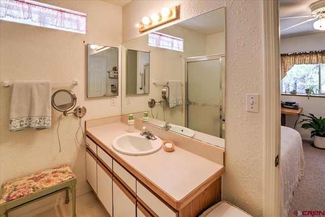 16 Mosswood Dr, Pagosa Springs, CO 81147 - bathroom featuring a textured wall, a shower with shower door, and vanity