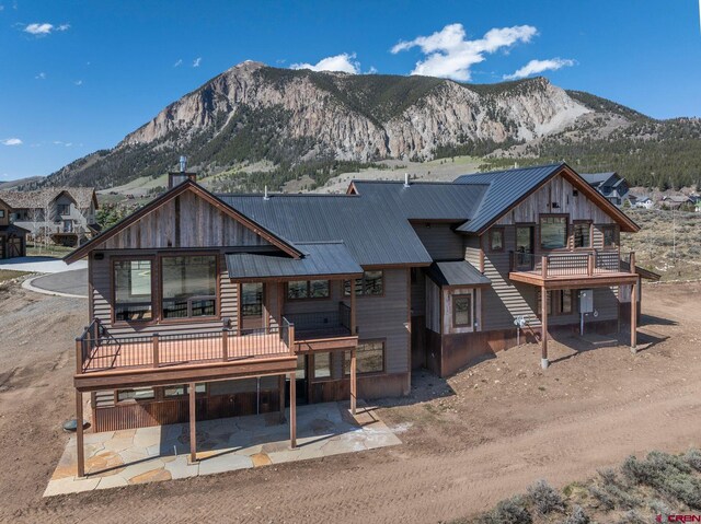 70 Lexie Ct, Crested Butte, CO 81224 - view of front of home featuring a mountain view, metal roof, a balcony, and a patio