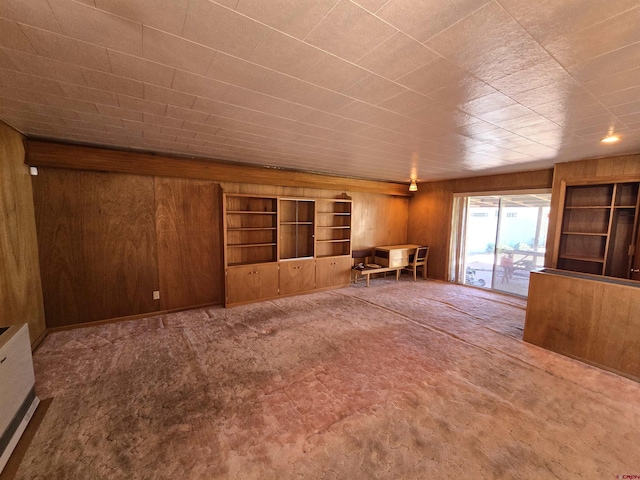 spare room featuring wooden walls and carpet flooring