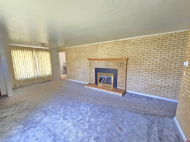 unfurnished living room with brick wall, a fireplace, carpet flooring, and a textured ceiling