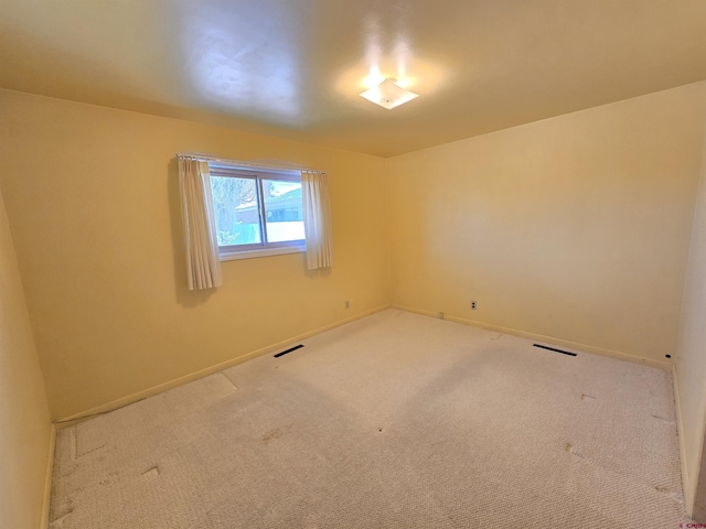 empty room featuring carpet floors and baseboards