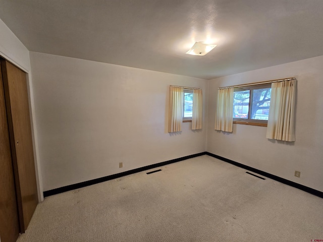 empty room with light carpet and baseboards