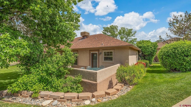 2384 Ridge Circle Dr Unit 14, Grand Junction, CO 81507 - back of house with stucco siding, a shingled roof, and a lawn