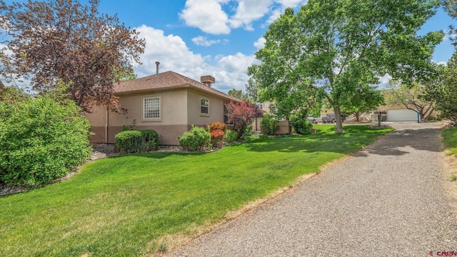 2384 Ridge Circle Dr Unit 14, Grand Junction, CO 81507 - view of side of property featuring stucco siding, a yard, and a garage