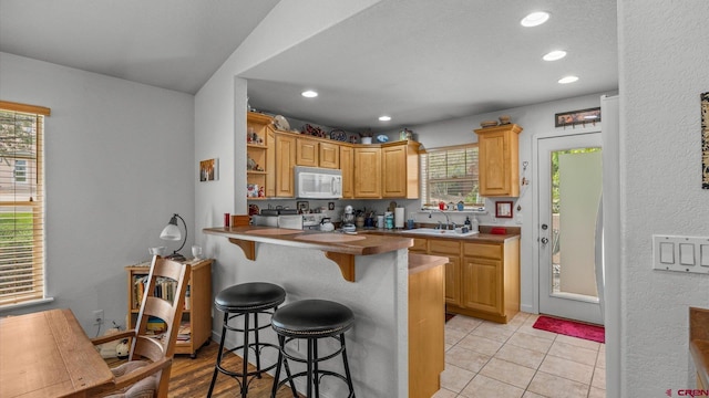 2384 Ridge Circle Dr Unit 14, Grand Junction, CO 81507 - kitchen with white microwave, a kitchen bar, a sink, a peninsula, and recessed lighting