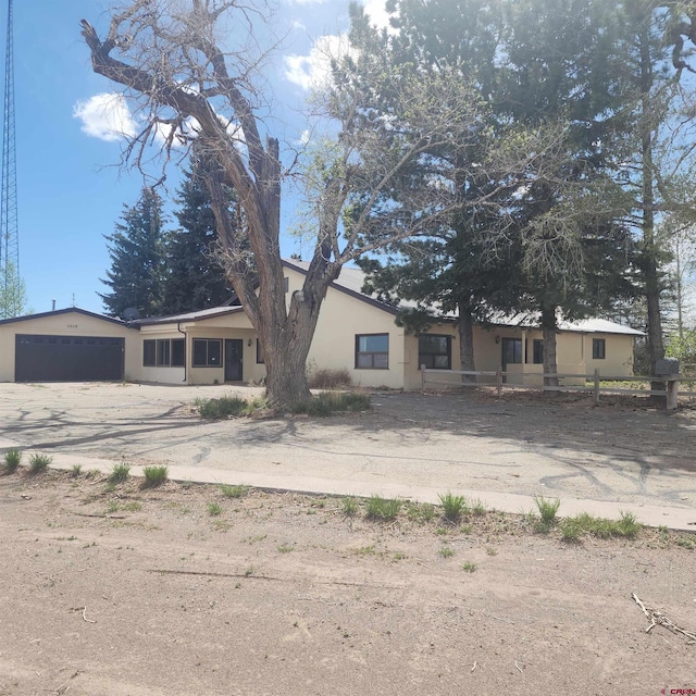 1016 Ln 12 N, Hooper, CO 81136 - view of front of property with asphalt driveway, stucco siding, a garage, and fence