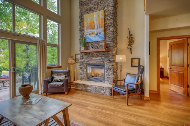 135 Eaton Dr Unit 1012, Pagosa Springs, CO 81147 - living room featuring a towering ceiling, a stone fireplace, and wood finished floors
