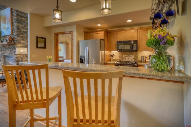 135 Eaton Dr Unit 1012, Pagosa Springs, CO 81147 - kitchen with appliances with stainless steel finishes, hanging light fixtures, decorative backsplash, recessed lighting, and a breakfast bar area