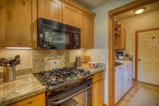 135 Eaton Dr Unit 1012, Pagosa Springs, CO 81147 - kitchen with black appliances, independent washer and dryer, light tile patterned flooring, and light stone counters