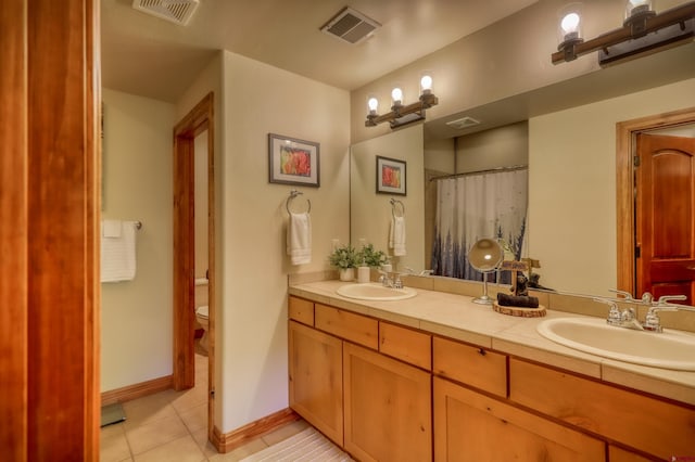 135 Eaton Dr Unit 1012, Pagosa Springs, CO 81147 - bathroom with tile patterned floors, toilet, double vanity, and baseboards