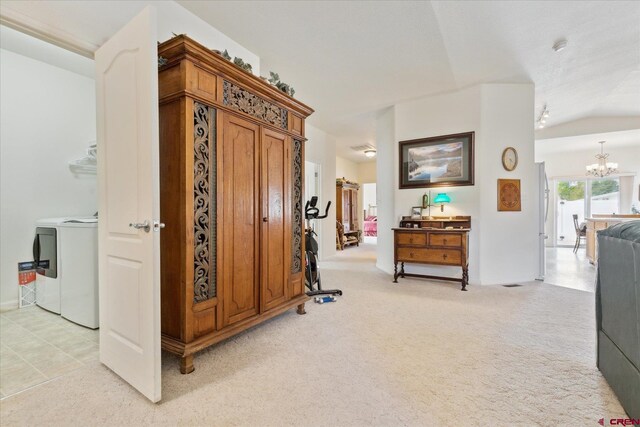 502 S Juniper Pl, Cortez, CO 81321 - corridor featuring a chandelier, light carpet, and washing machine and clothes dryer