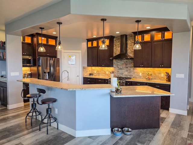 1771 Trappers Ct, Delta, CO 81416 - kitchen with wall chimney range hood, stainless steel appliances, wood finished floors, dark brown cabinets, and recessed lighting