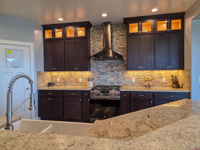 1771 Trappers Ct, Delta, CO 81416 - kitchen with wall chimney range hood, stainless steel gas range oven, a sink, dark brown cabinets, and light stone counters