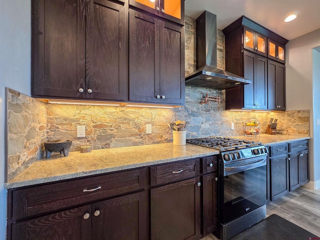 1771 Trappers Ct, Delta, CO 81416 - kitchen with stainless steel range with gas cooktop, wall chimney range hood, dark brown cabinets, decorative backsplash, and glass insert cabinets