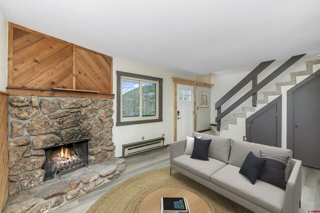 22 Castle Rd Unit 2, Mount Crested Butte, CO 81225 - living room featuring baseboard heating, wood finished floors, stairway, and a fireplace