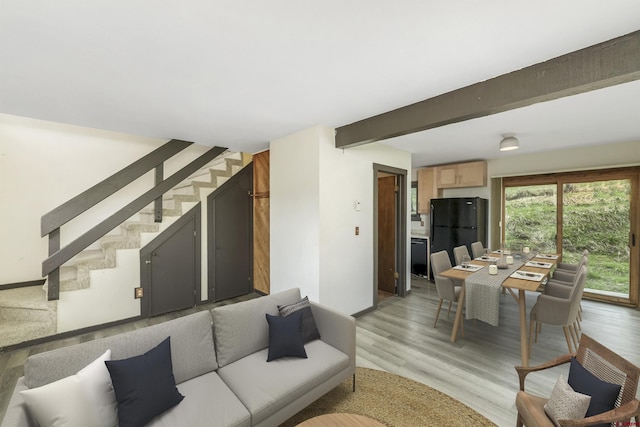 22 Castle Rd Unit 2, Mount Crested Butte, CO 81225 - living room featuring stairs, light wood-type flooring, baseboards, and beam ceiling